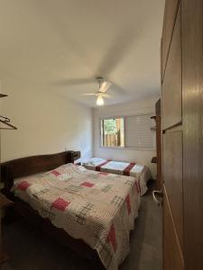 ein Schlafzimmer mit zwei Betten und einem Fenster in der Unterkunft Vilarejo Leme in São Sebastião + 21 Fotos