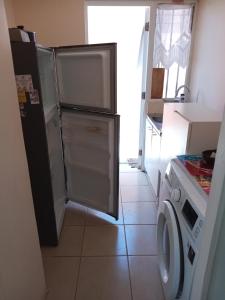 a kitchen with a refrigerator and a washing machine at Casa Alto las Pircas in Coquimbo +10 photos