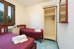 a small room with two beds and a closet at Casa Vacanza Azzurra 4 in San Vito lo Capo