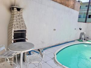 a patio with a table and chairs next to a pool at Casa de 2 QUARTOS COM PISCINA in Balneário Camboriú