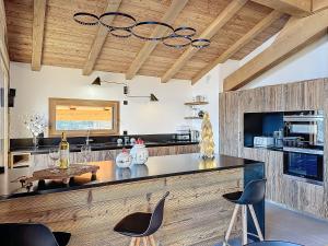 cocina con encimera con sillas y mesa en Chalet Combloran, en Combloux