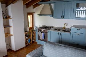 a kitchen with blue cabinets and a stove top oven at Casa Caravino in Varenna
