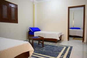 库塞尔Amoaj hotel فندق امواج的有两张床、一把椅子和一面镜子的房间