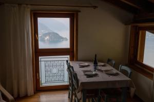 a dining room with a table and a large window at Casa Caravino in Varenna