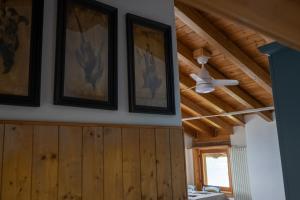 a room with a ceiling fan and pictures on the wall at Casa Caravino in Varenna +19 photos