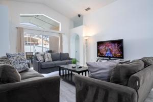 a living room with two couches and a tv at casa em orlando perto da disney com piscina house in area disney in Kissimmee