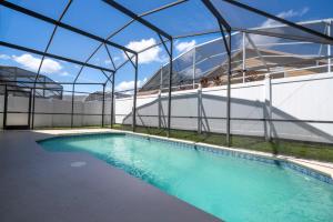 a swimming pool inside a building with a glass roof at casa em orlando perto da disney com piscina house in area disney in Kissimmee