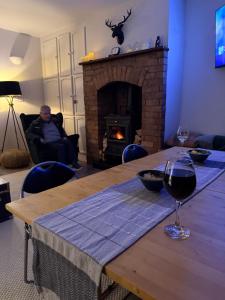 a living room with a table and a fireplace at Trábréaga Cottage in Ballyliffin