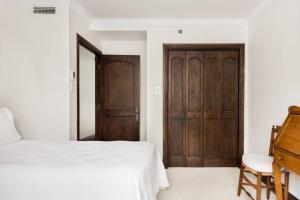 a bedroom with a bed and a wooden door at Prime Location Village Home - Bondurant 95-4 in Mont-Tremblant +31 photos