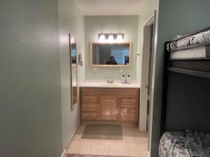 a bathroom with a sink and a mirror and a bed at RR-Birch_Creek 2 in June Lake