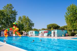 a swimming pool with people in the water at Cesenatico Camping Village in Cesenatico