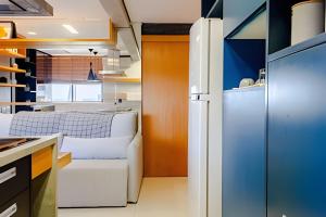 a kitchen with a white couch and a refrigerator at Golden Ingá Hotel Flat in Maringá +48 photos