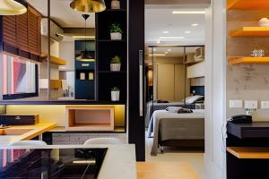 a room with a bedroom and a bed and a desk at Golden Ingá Hotel Flat - Apartamento in Maringá