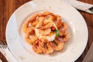 a white plate with shrimp on a table at Hotel Sonata de Iracema in Fortaleza
