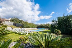 een tuin met een zwembad en lawnitures bij De Casa Villa by GALMI in Estreito da Calheta