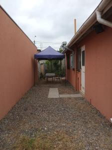 a patio with a blue umbrella and a table at Casa Alto las Pircas in Coquimbo
