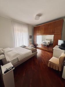 a bedroom with a large bed and a living room at Montesanto 25 in Cosenza