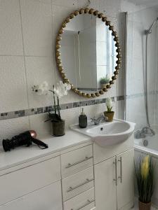 a bathroom with a sink and a mirror at Cosy Luxurious Room in The Heart of London in London