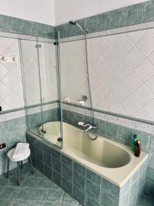 a bathroom with a tub with a shower and a stool at Montesanto 25 in Cosenza +29 photos
