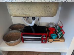 a toaster oven sitting on a shelf under a sink at Casa com Conforto, Tranquilidade em Meio à Natureza in Gonçalves +11 photos