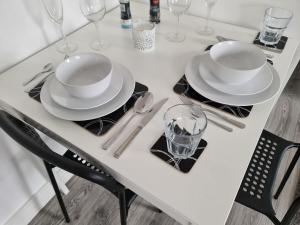 a white table with plates and glasses on it at SAV Stays Apartments Nottingham Road Loughborough in Loughborough