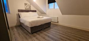 a bedroom with a large bed in a attic at SAV Stays Apartments Nottingham Road Loughborough in Loughborough