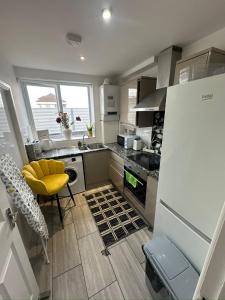 a kitchen with a yellow chair and a sink at Cosy Luxurious Room in The Heart of London in London