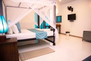 a bedroom with a bed with a canopy at Alnaro Hotel & Resort in Moratuwa