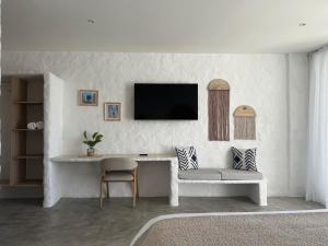 a living room with a table and a tv on a wall at MYLOS Hotel Boutique in Guatapé