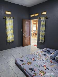 a bedroom with a bed in a room with a door at VILLA BIRU PANTAI GOA LANGIR Sawarna in Sawarna