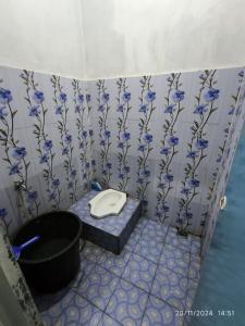 a bathroom with a toilet with blue flowers on the wall at VILLA BIRU PANTAI GOA LANGIR Sawarna in Sawarna +19 photos