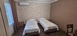 ein Hotelzimmer mit zwei Betten und einem Fenster in der Unterkunft Стаи за гости Георги Сава Раковски 97 in Targowischte