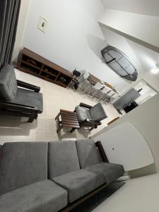 a living room with a couch and some chairs at Geminado Itaguaçu - São Francisco do Sul in São Francisco do Sul