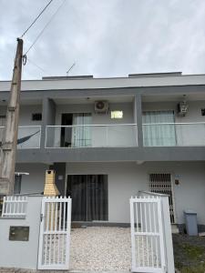 a house with two white gates in front of it at Geminado Itaguaçu - São Francisco do Sul in São Francisco do Sul