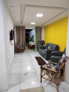 una sala de estar con sofás y una pared amarilla en ILHA De ITAPARICA PONTA DE AREIA CASA DA NÉIA TEMPORADA, en Itaparica