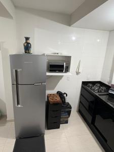 a kitchen with a refrigerator and a microwave at Geminado Itaguaçu - São Francisco do Sul in São Francisco do Sul