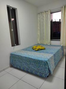 Una cama en una habitación con una almohada de plátano. en ILHA De ITAPARICA PONTA DE AREIA CASA DA NÉIA TEMPORADA, en Itaparica