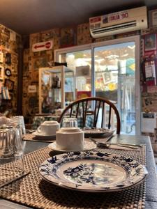 a table with plates and utensils on it at La Nueva Posadita in Colonia del Sacramento +40 photos