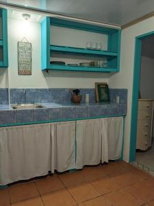 Una cocina con gabinetes azules y un fregadero. en Delightful garden apartment, 2 min to beach, en Cahuita
