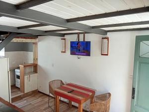 a room with a table and a tv on a wall at Azul en Lavalle 6 in Azul