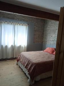 a bedroom with a bed and a brick wall at Azul en Lavalle 6 in Azul