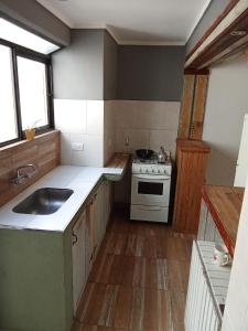a kitchen with a sink and a stove at Azul en Lavalle 6 in Azul