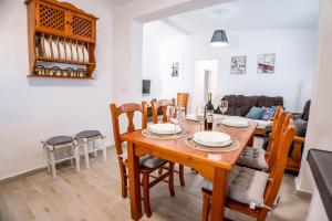 a dining room and living room with a table and chairs at Casa Petra in Vejer de la Frontera