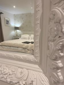 a white bedroom with a large mirror on the wall at Abbey Green Farm in Wem