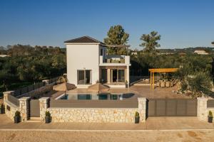 a villa with a swimming pool and a house at Villa Pagliaricci in Gaïtánion