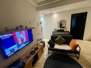 a living room with a flat screen tv and a couch at Les Nuits de Miel - Marrakech in Marrakech