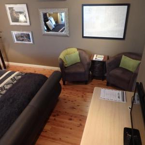 a bedroom with a bed and two chairs and a table at Bowral Road Art Gallery Bed and Breakfast in Mittagong
