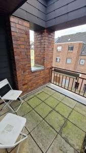 a patio with two chairs and a brick building at Zimmer D in Mönchengladbach