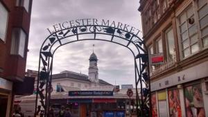 a gate in a city with a clock tower at SAV Stays Apartments Regent Leicester in Leicester
