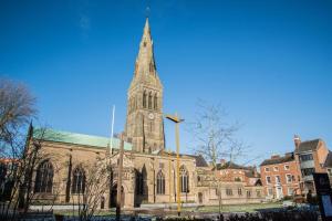 a church with a tall tower with a clock on it at SAV Stays Apartments Regent Leicester in Leicester +7 photos